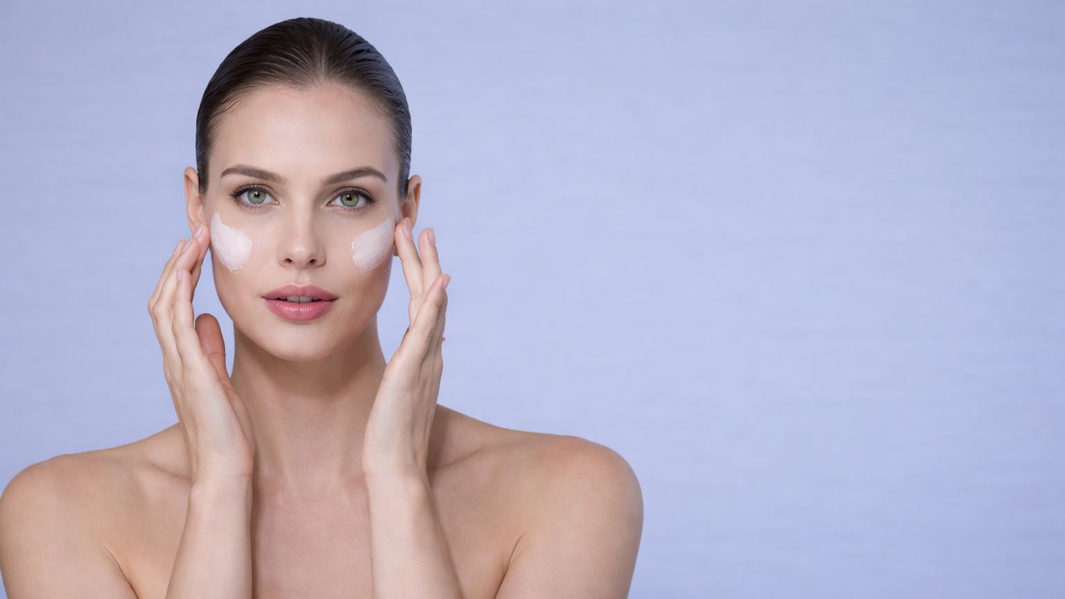Woman applying cream to her face against a light purple background